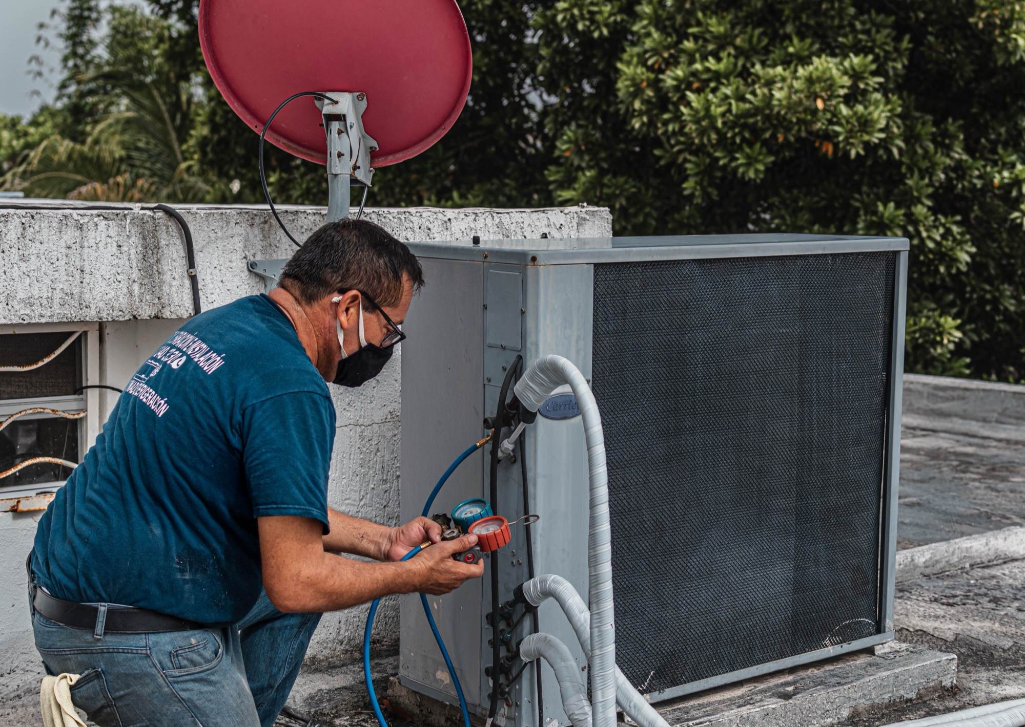 Broward AC Guys technician servicing a rooftop air conditioning condenser in South Florida